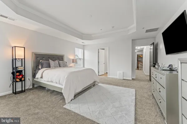 a spacious bedroom with a bed and a flat screen television