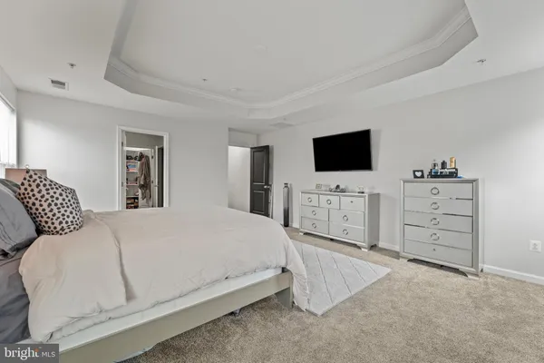 a spacious bedroom with a bed and a flat screen tv