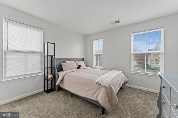 a bedroom with a bed next to a window