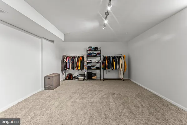 an empty room with baby crib and a chandelier