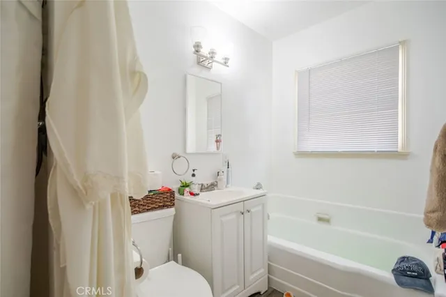 a bathroom with a sink toilet vanity and bathtub