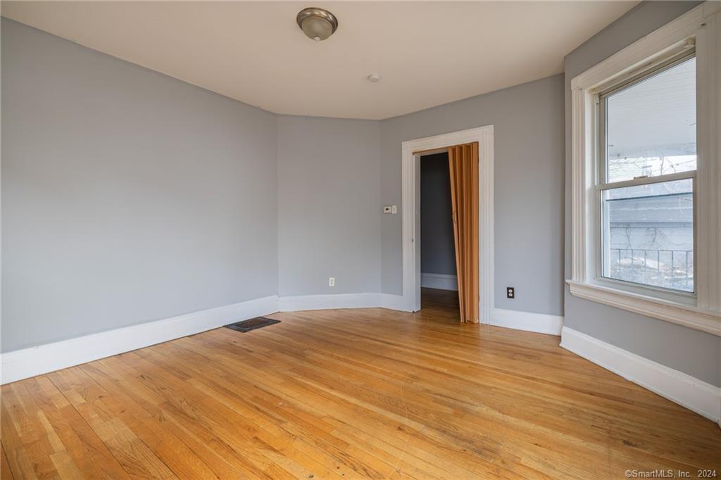 26 Pleasant Street Bridgeport, CT 06608 - Photo 3 of 15 a view of an empty room with wooden floor and a window