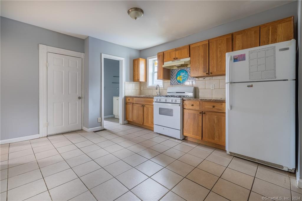 26 Pleasant Street Bridgeport, CT 06608 - Photo 5 of 15 a kitchen with white cabinets and white appliances