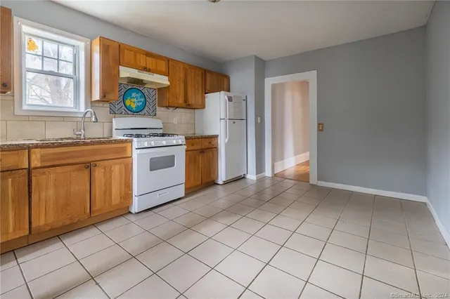 a kitchen with stainless steel appliances granite countertop a stove a sink and a refrigerator