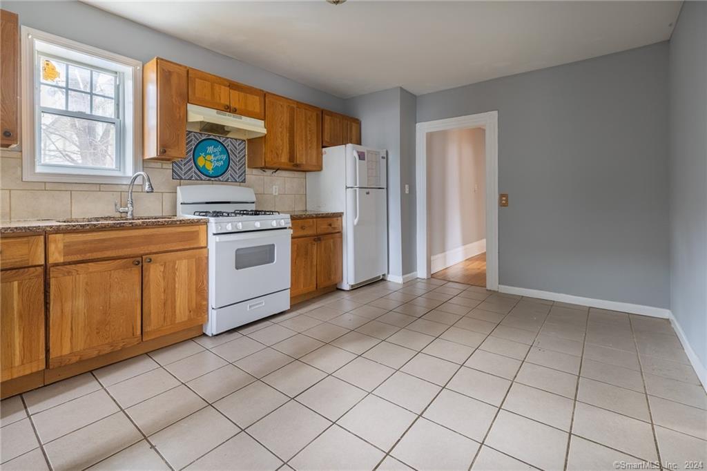 26 Pleasant Street Bridgeport, CT 06608 - Photo 6 of 15 a kitchen with stainless steel appliances granite countertop a stove a sink and a refrigerator