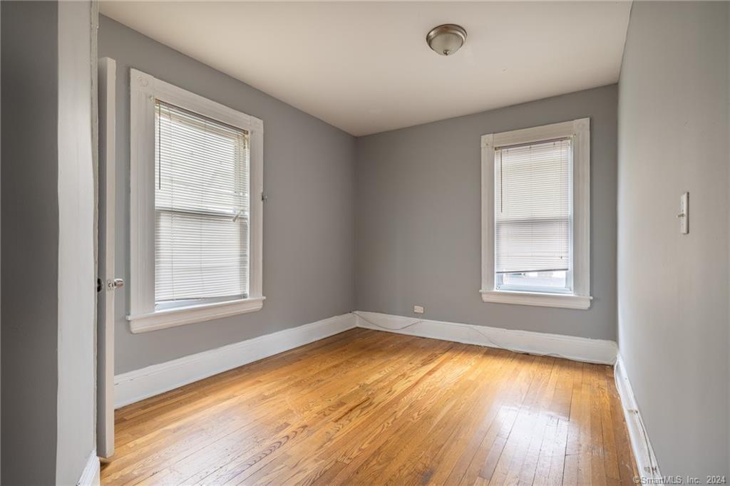 26 Pleasant Street Bridgeport, CT 06608 - Photo 10 of 15 an empty room with a window and wooden floor