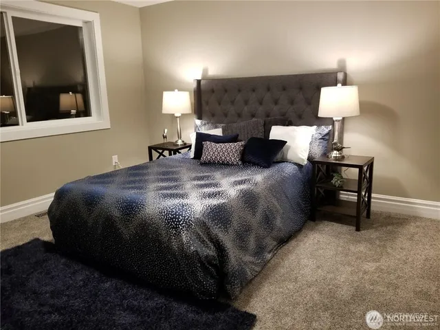 a bedroom with a bed and a lamp on table