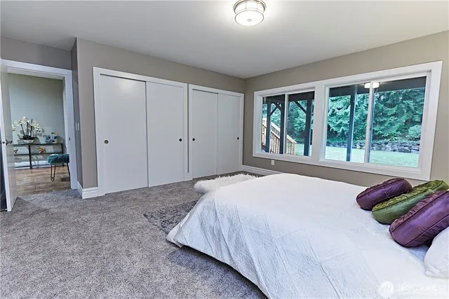 a bedroom with a bed and a large window