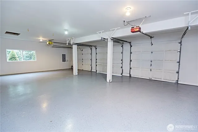 an empty room with windows and ceiling fan