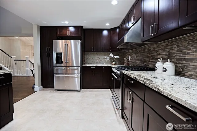 a kitchen with kitchen island granite countertop a sink stainless steel appliances and cabinets