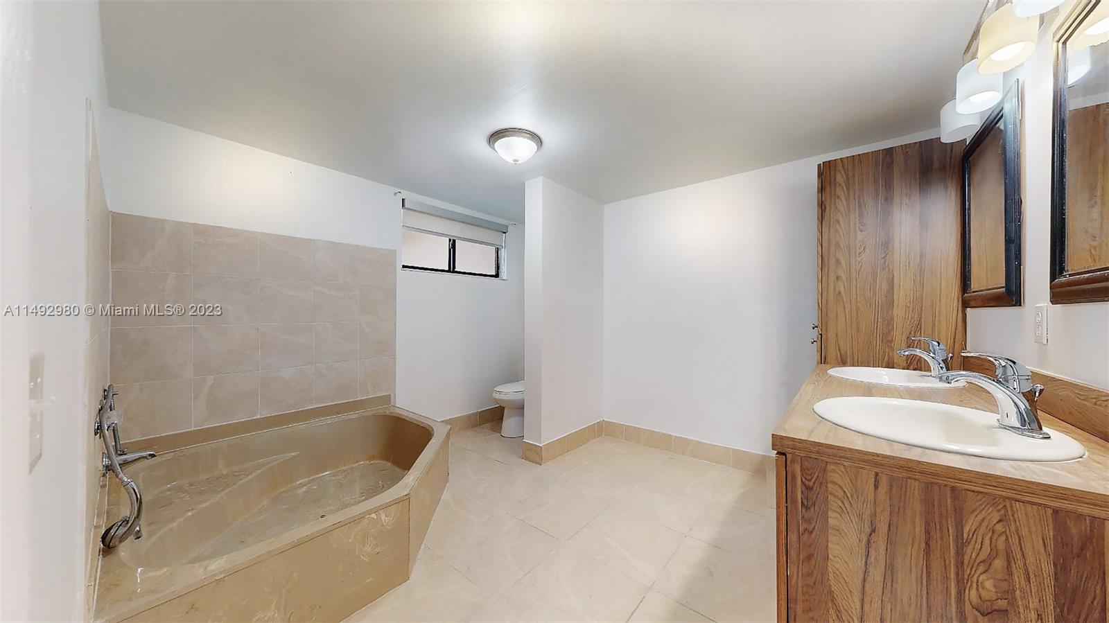 491 Ives Dairy Road, Unit 3055 Miami, FL 33179 - Photo 12 of 24 a bathroom with a granite countertop sink and a bathtub