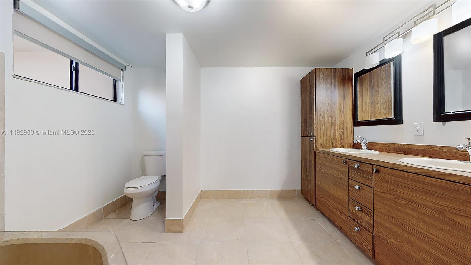 491 Ives Dairy Road, Unit 3055 Miami, FL 33179 - Photo 13 of 24 a bathroom with a toilet sink and mirror
