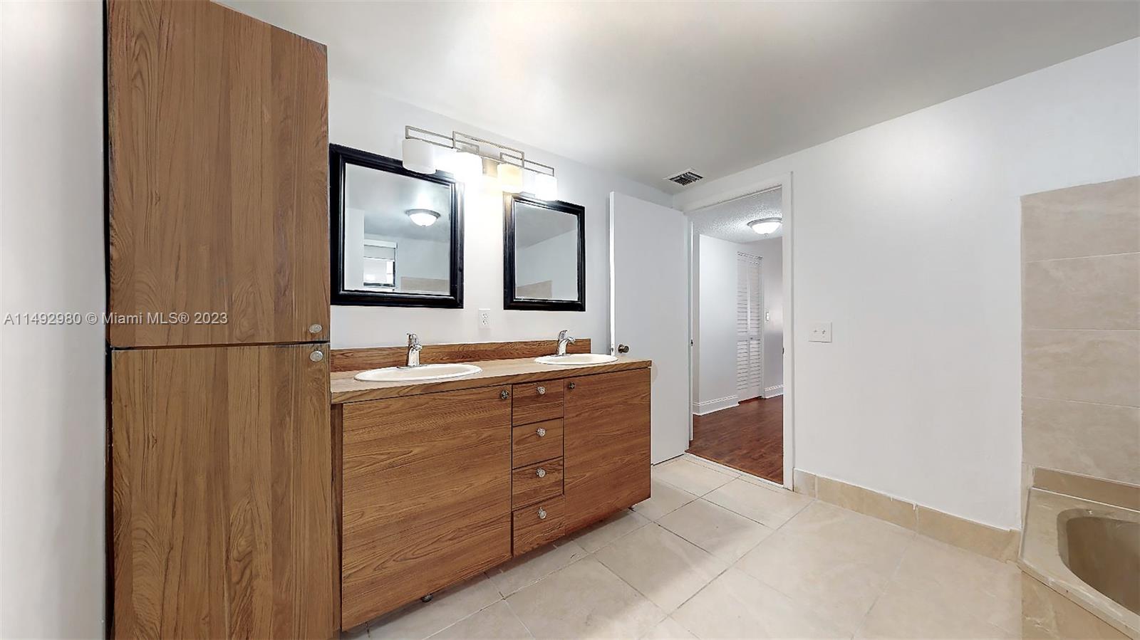 491 Ives Dairy Road, Unit 3055 Miami, FL 33179 - Photo 14 of 24 a bathroom with a double vanity sink and mirror