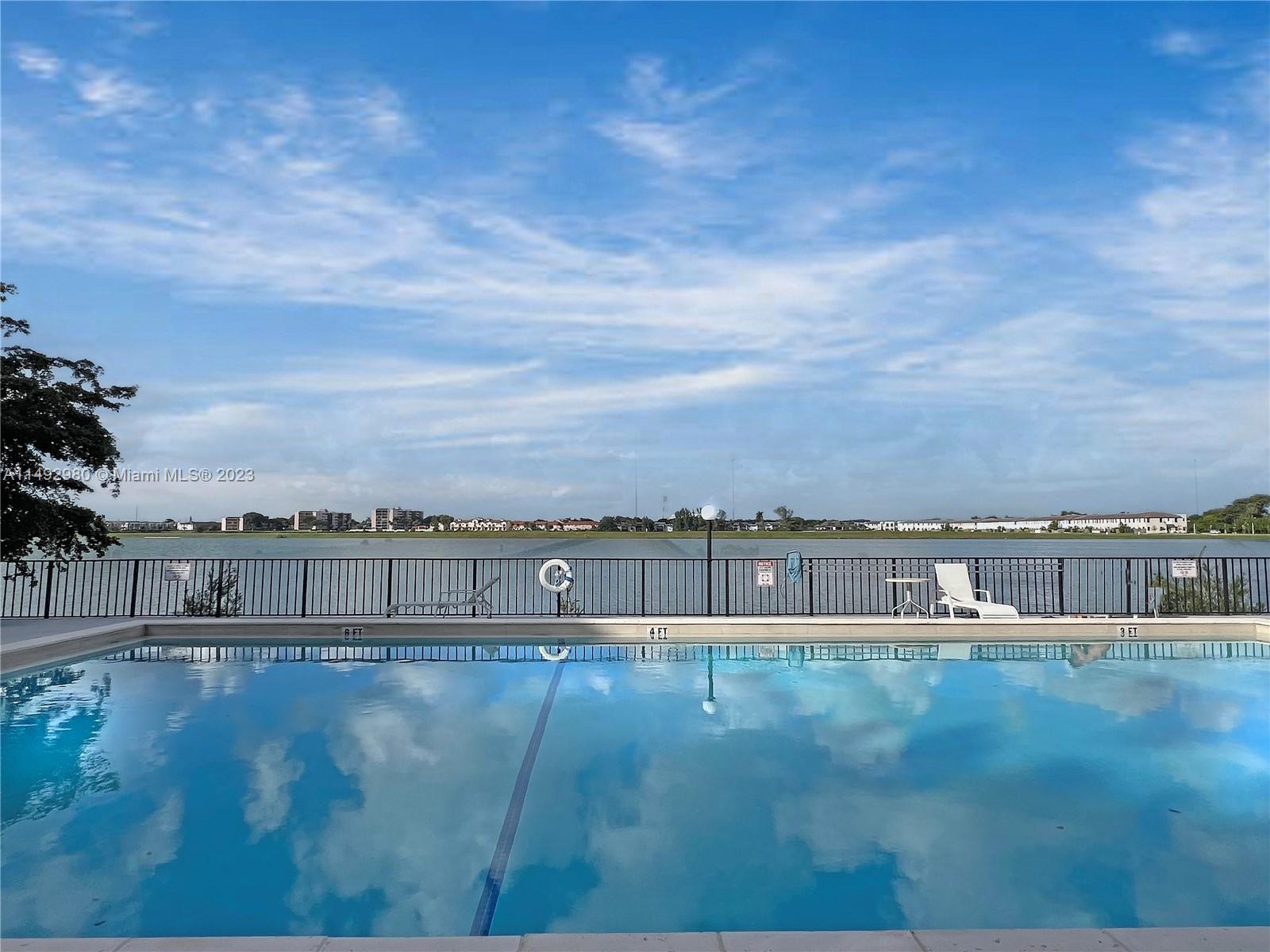 491 Ives Dairy Road, Unit 3055 Miami, FL 33179 - Photo 16 of 24 a view of swimming pool with a yard and large tree in the background
