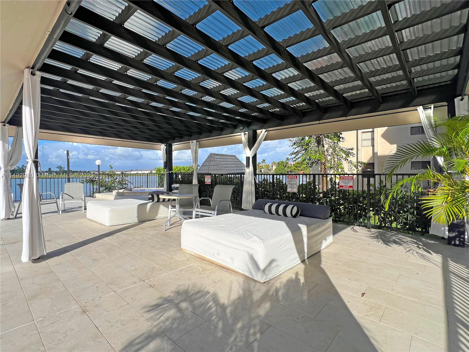 491 Ives Dairy Road, Unit 3055 Miami, FL 33179 - Photo 18 of 24 a outdoor space with patio lots of furniture and chandelier