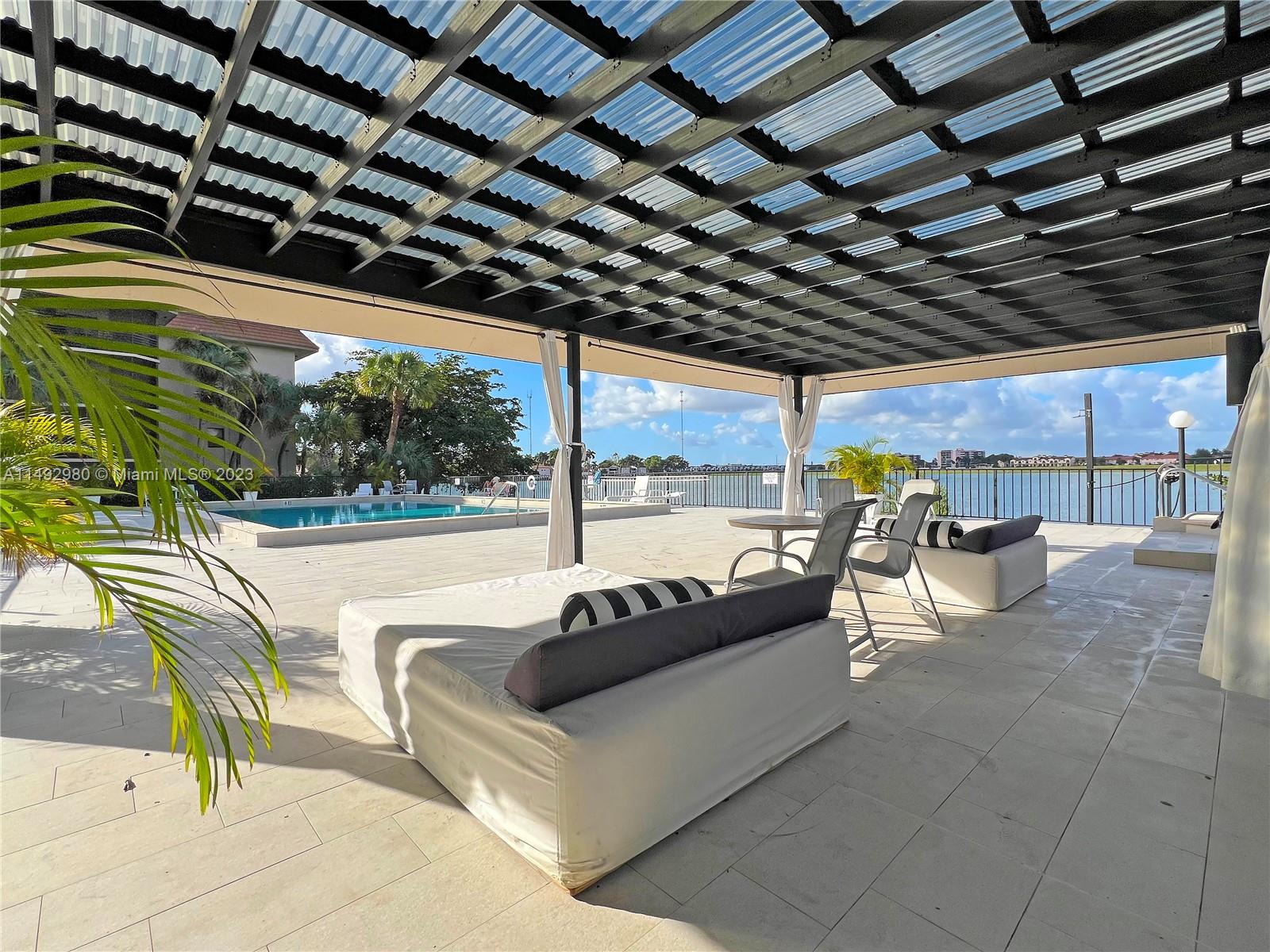 491 Ives Dairy Road, Unit 3055 Miami, FL 33179 - Photo 20 of 24 a view of a patio with a table and chairs