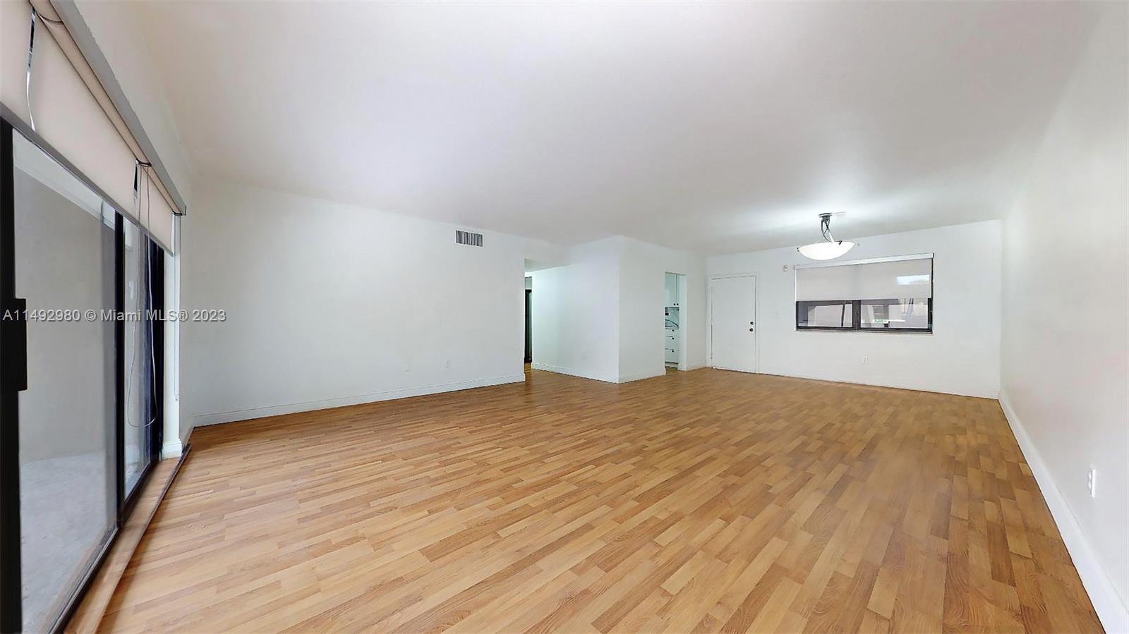 491 Ives Dairy Road, Unit 3055 Miami, FL 33179 - Photo 3 of 24 a view of empty room with wooden floor