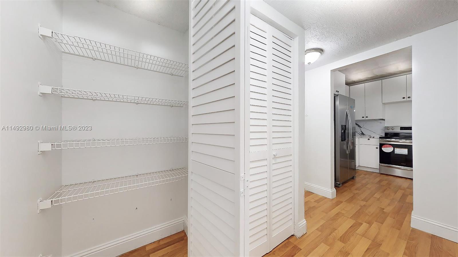 491 Ives Dairy Road, Unit 3055 Miami, FL 33179 - Photo 5 of 24 a view of a hallway with wooden floor windows and a bathroom