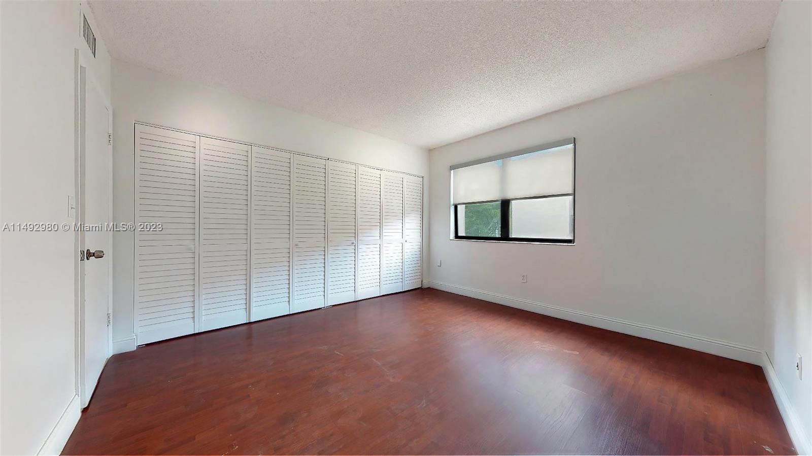 491 Ives Dairy Road, Unit 3055 Miami, FL 33179 - Photo 7 of 24 an empty room with wooden floor and windows
