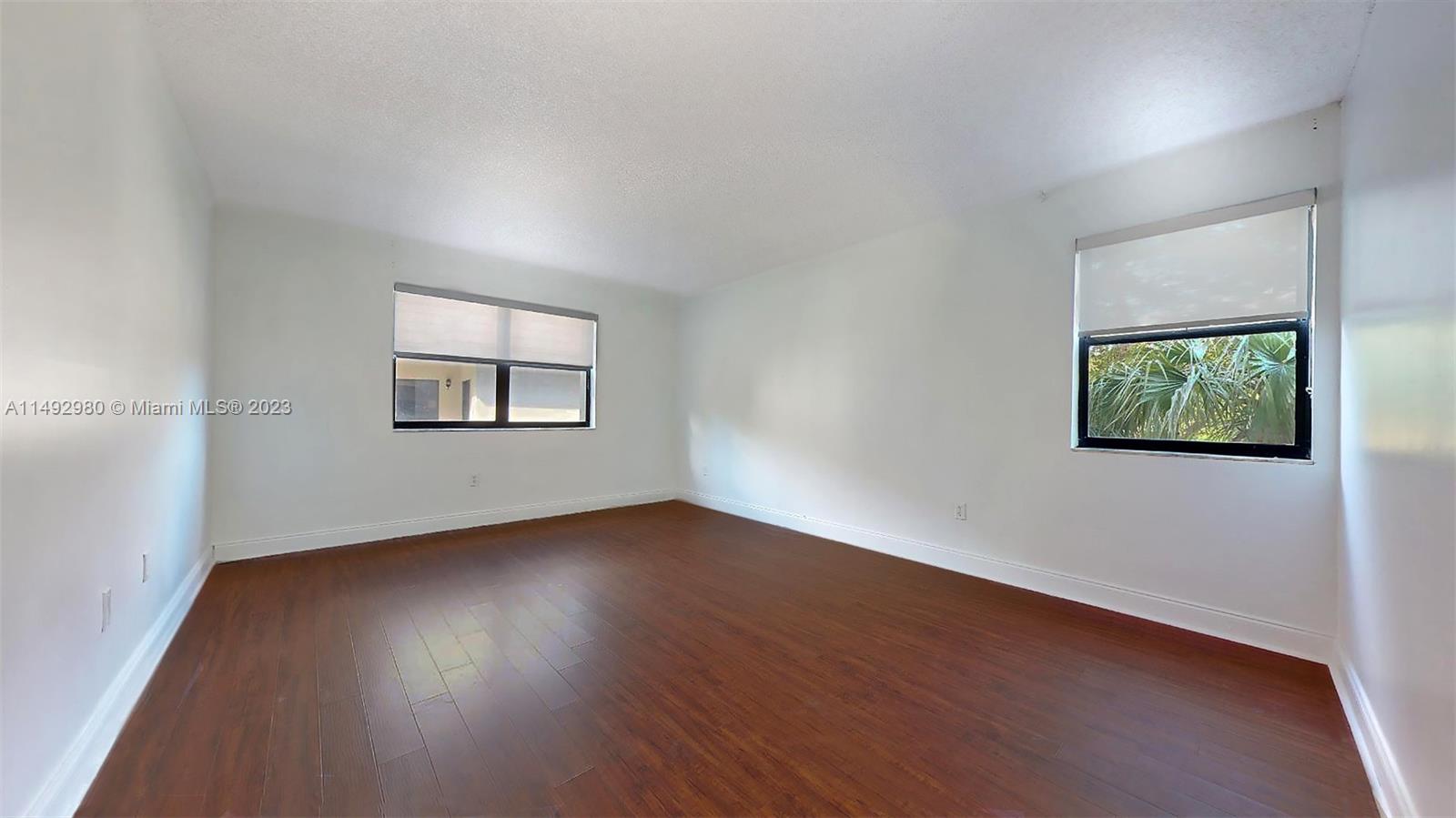 491 Ives Dairy Road, Unit 3055 Miami, FL 33179 - Photo 9 of 24 a view of an empty room with wooden floor and a window