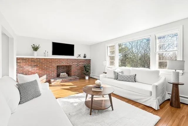 a living room with furniture a flat screen tv and a large window