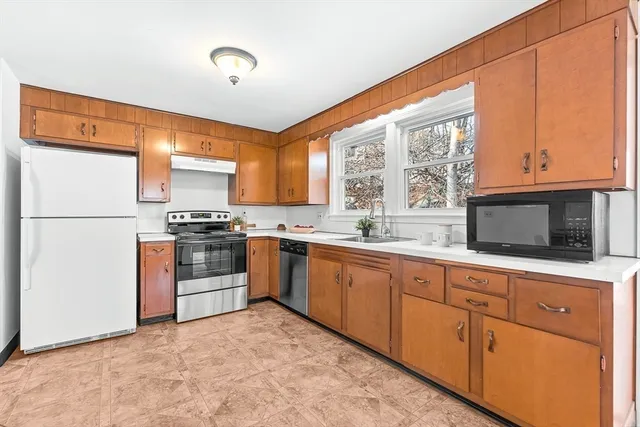 a kitchen with stainless steel appliances granite countertop a refrigerator sink and stove