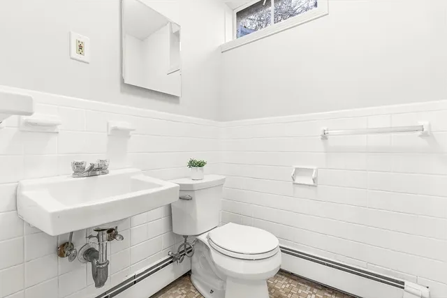 a bathroom with a sink a toilet and mirror