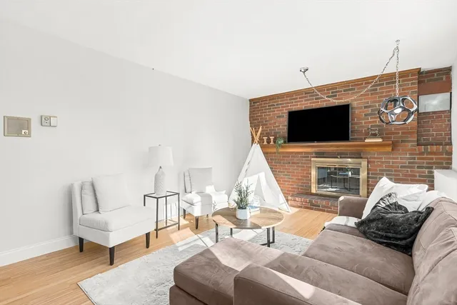 a living room with furniture a flat screen tv and a fireplace