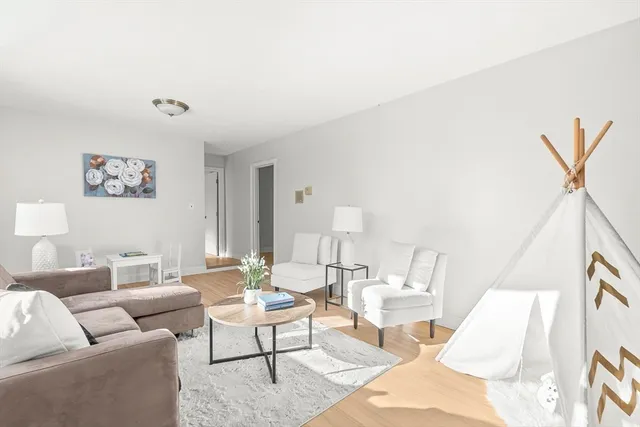 a living room with furniture a rug and a painting on the wall