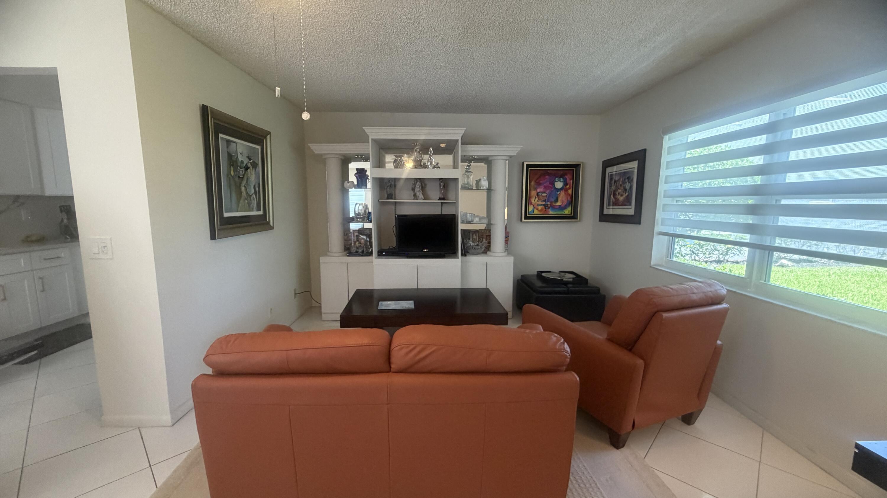 930 Normandy Trail Delray Beach, FL 33484 - Photo 2 of 34 a living room with furniture and a flat screen tv