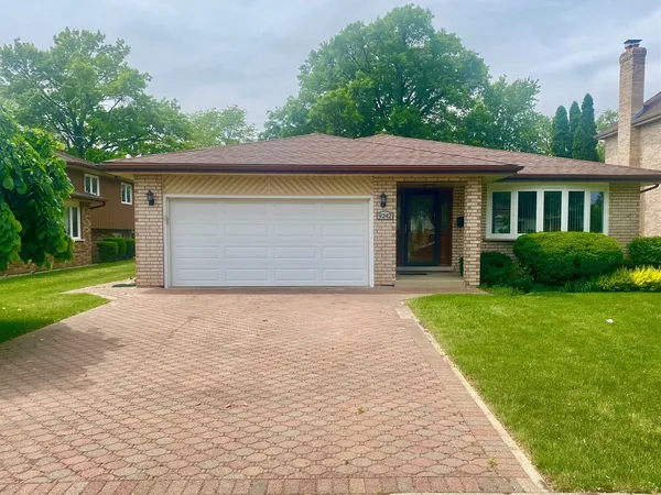 a front view of a house with a garden and yard