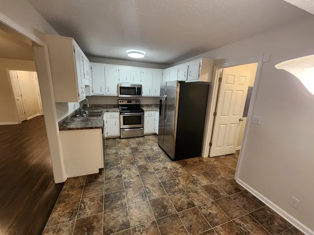 a kitchen with stainless steel appliances granite countertop a refrigerator and a stove