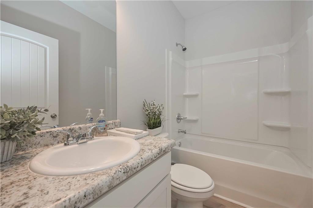 505 Charleston Place Villa Rica, GA 30180 - Photo 17 of 35 a bathroom with a granite countertop sink toilet and shower