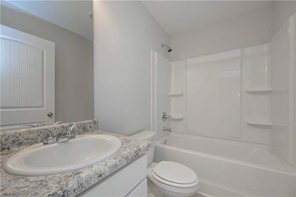 505 Charleston Place Villa Rica, GA 30180 - Photo 22 of 35 a bathroom with a granite countertop sink toilet and shower