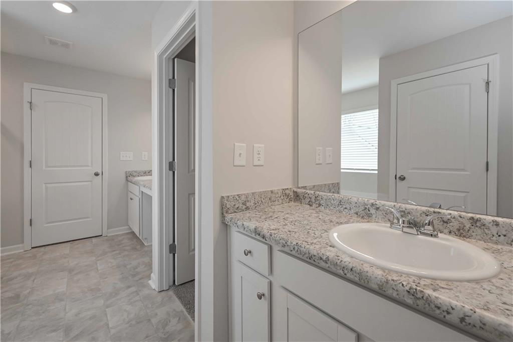 505 Charleston Place Villa Rica, GA 30180 - Photo 33 of 35 a bathroom with a granite countertop sink and a mirror