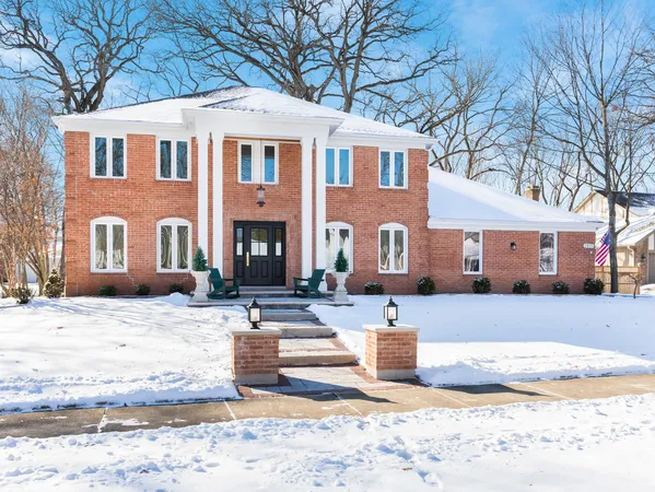 a front view of a house with a yard covered in snow