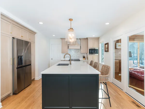 a large kitchen with a sink stainless steel appliances and cabinets