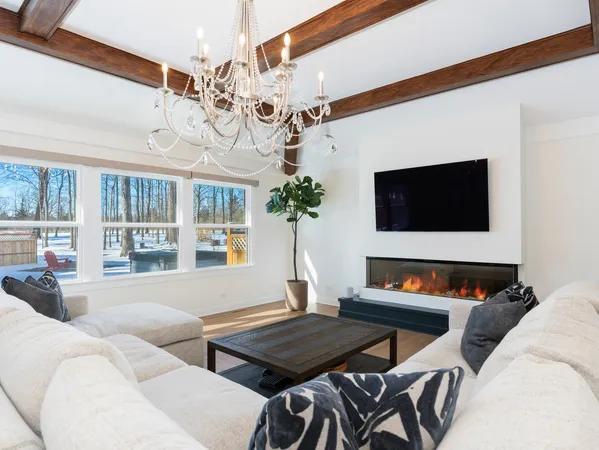 a living room with furniture a chandelier and a flat screen tv