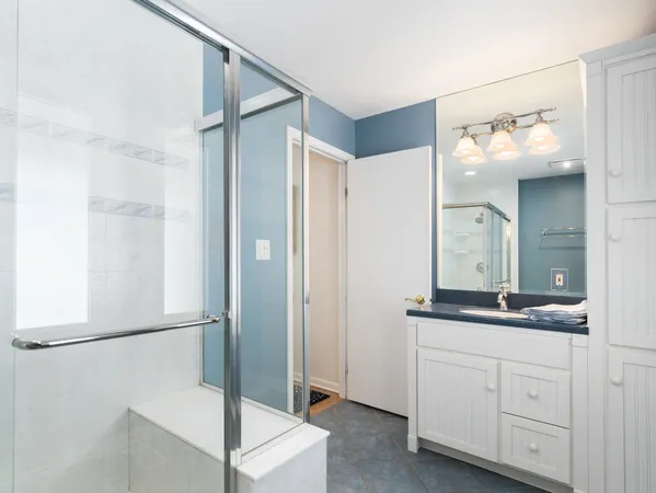 a bathroom with a granite countertop sink mirror and cabinets