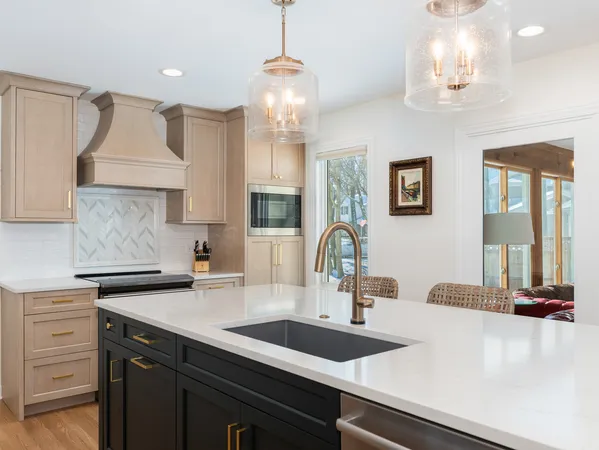 a kitchen with a sink dishwasher a dining table and chairs with wooden floor