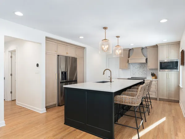 a kitchen with granite countertop a sink cabinets and wooden floor