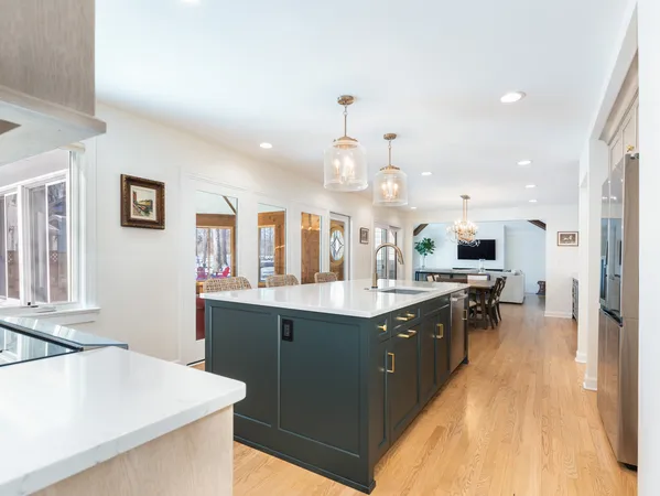 a large kitchen with stainless steel appliances a large counter top a stove a chimney a sink and a refrigerator