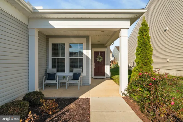 a view of a porch with chairs and potted plants