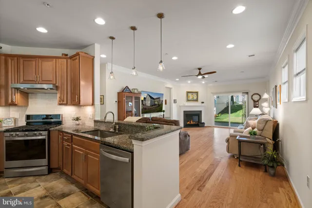 a kitchen with a stove a refrigerator and chairs