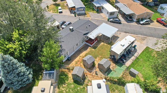 29 Grover Street Layton, UT 84041 - Photo 27 of 29 Aerial view of a property featuring a single-story residence with a dark shingled roof, an attached white carport, and a gravel driveway