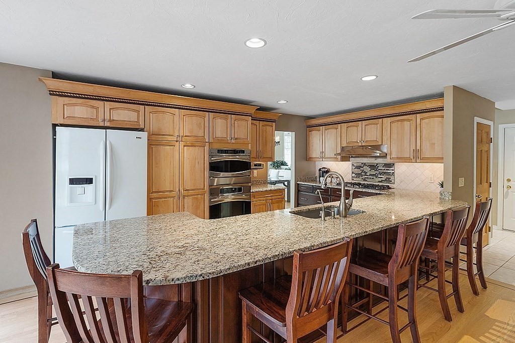 793 Reservoir Road Lunenburg, MA 01462 - Photo 11 of 39 a kitchen with granite countertop kitchen island stainless steel appliances a table and chairs