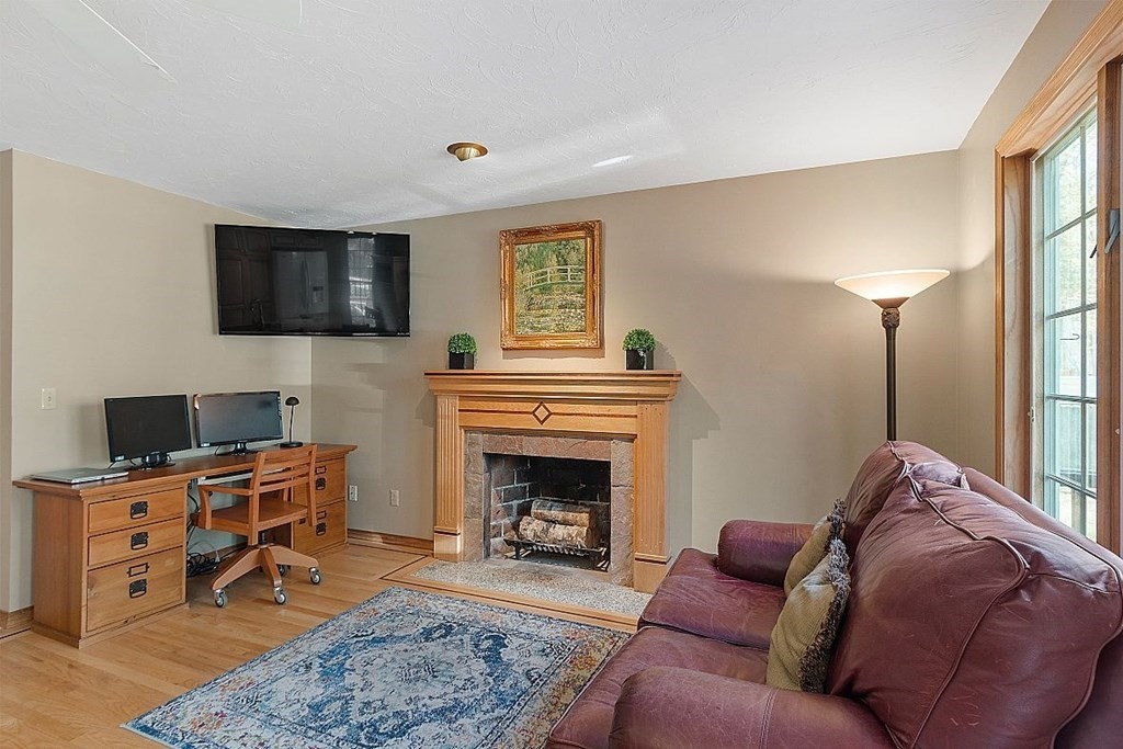 793 Reservoir Road Lunenburg, MA 01462 - Photo 12 of 39 a living room with furniture a fireplace and a flat screen tv