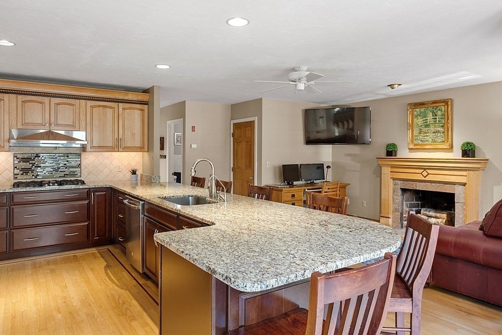 793 Reservoir Road Lunenburg, MA 01462 - Photo 13 of 39 a kitchen with granite countertop kitchen island stainless steel appliances a stove sink and cabinets