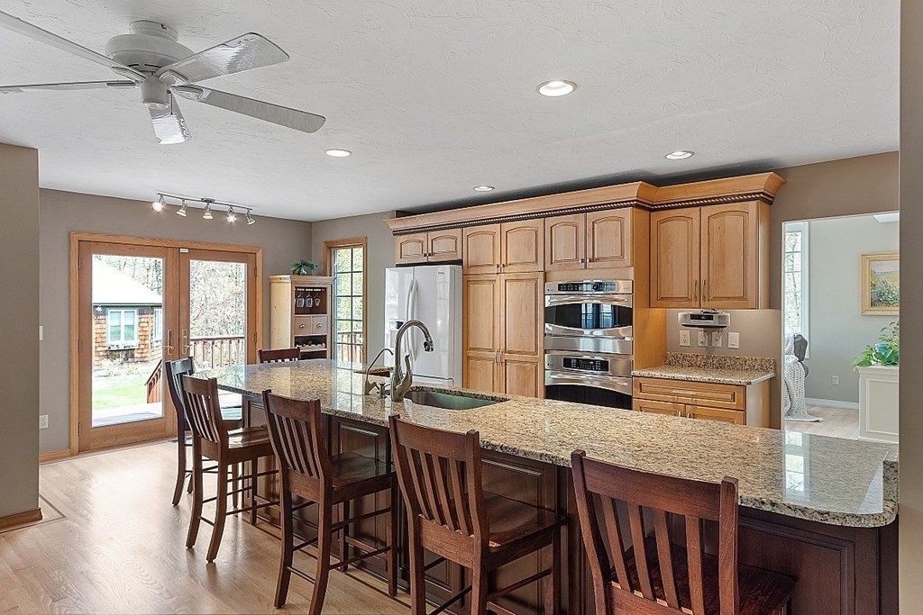 793 Reservoir Road Lunenburg, MA 01462 - Photo 14 of 39 a kitchen with stainless steel appliances granite countertop a stove a refrigerator a kitchen island a table and chairs