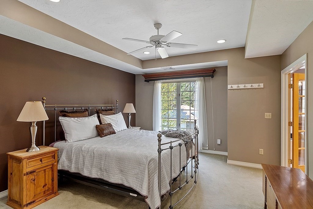 793 Reservoir Road Lunenburg, MA 01462 - Photo 18 of 39 a bedroom with a bed and a chandelier